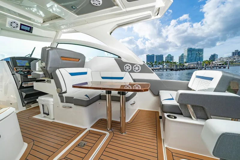 Slide: The Image of Manufacturer Provided Image: 2025 Tiara Yachts 34 LX interior with modern seating and wooden flooring, city skyline view. - 11