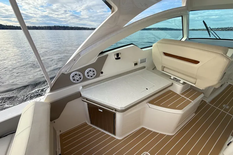 Slide: The Image of 2026 Tiara Yachts 34 LX interior with elegant seating and table on calm waters. - 21
