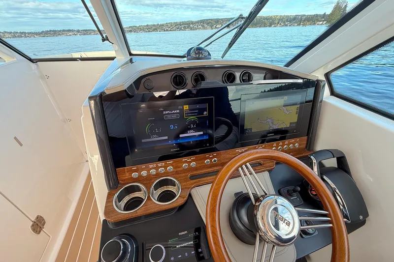 Slide: The Image of Helm of 2026 Tiara Yachts 34 LX with advanced navigation displays and wooden steering wheel. - 29