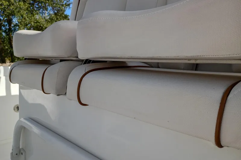 Slide: The Image of 2021 Sea Hunt Gamefish 27 Coffin Box boat seating detail, featuring white cushioned seats. - 24