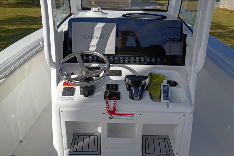 Slide: The Image of 2021 Sea Hunt Gamefish 27 Coffin Box boat console with Garmin display and steering wheel. - 46