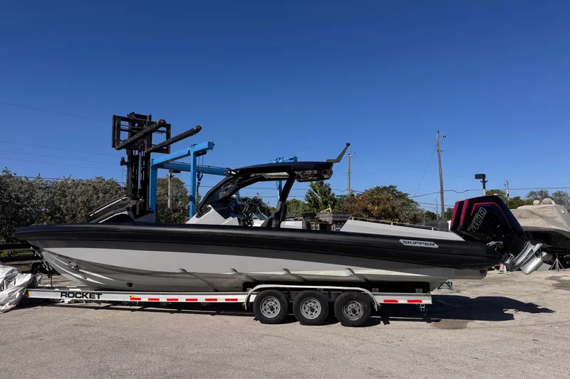Slide: The Image of 2025 Skipper-BSK 38NC boat on trailer under clear blue sky. - 1