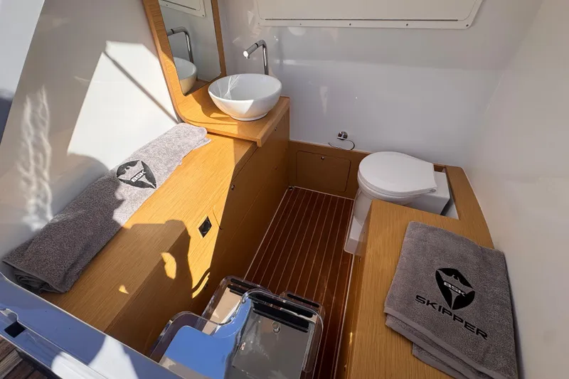 Slide: The Image of Luxurious bathroom in 2025 Skipper-BSK 38NC boat with modern fixtures and branded towels. - 17