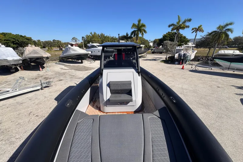 Slide: The Image of 2025 Skipper-BSK 38NC boat on display, surrounded by other covered boats and palm trees. - 23