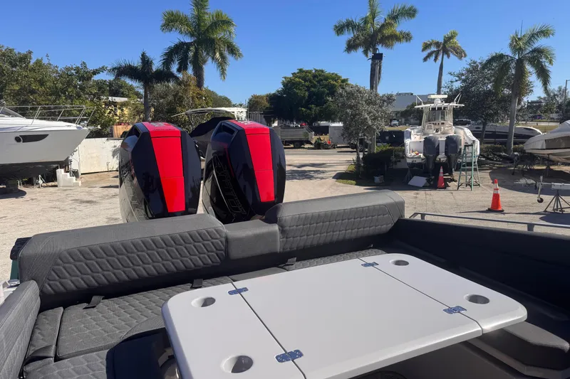 Slide: The Image of 2025 Skipper-BSK 38NC boat with dual engines, docked under palm trees. - 5