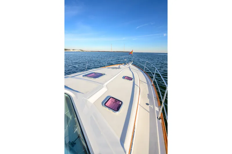 Slide: The Image of 2009 Sabre 42 Hard Top Express yacht cruising on open water under clear blue skies. - 10