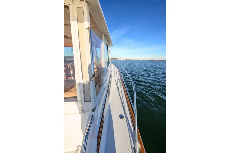 Slide: The Image of 2009 Sabre 42 Hard Top Express yacht cruising on calm waters under clear blue skies. - 11