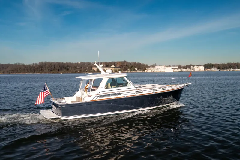Slide: The Image of 2009 Sabre 42 Hard Top Express cruising on a calm lake under a clear blue sky. - 2