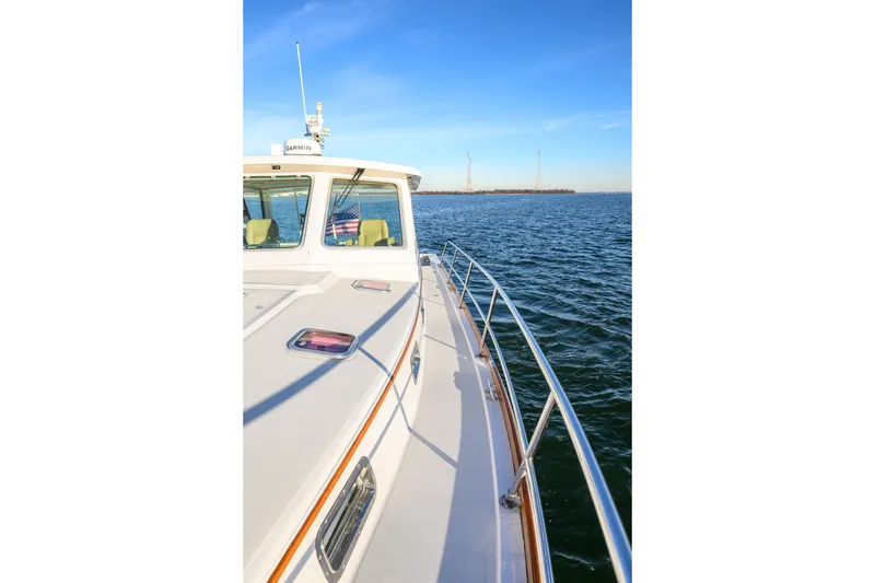 Slide: The Image of 2009 Sabre 42 Hard Top Express cruising on open water under clear blue skies. - 24
