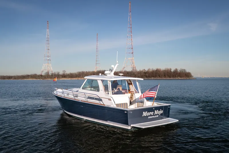 Slide: The Image of 2009 Sabre 42 Hard Top Express boat cruising on a calm waterway. - 5