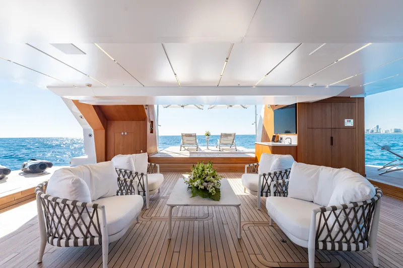 Slide: The Image of Luxurious Sanlorenzo 44 Alloy yacht deck with elegant seating, ocean view, and city skyline. - 9