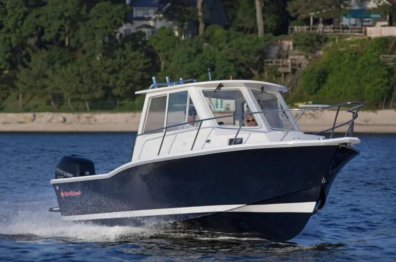 The Image of 2024 NorthCoast 235 HT boat cruising on water near a scenic shoreline. - 0