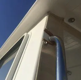 Slide: The Image of 2024 NorthCoast 235 HT boat exterior detail with railing and window under clear sky. - 17