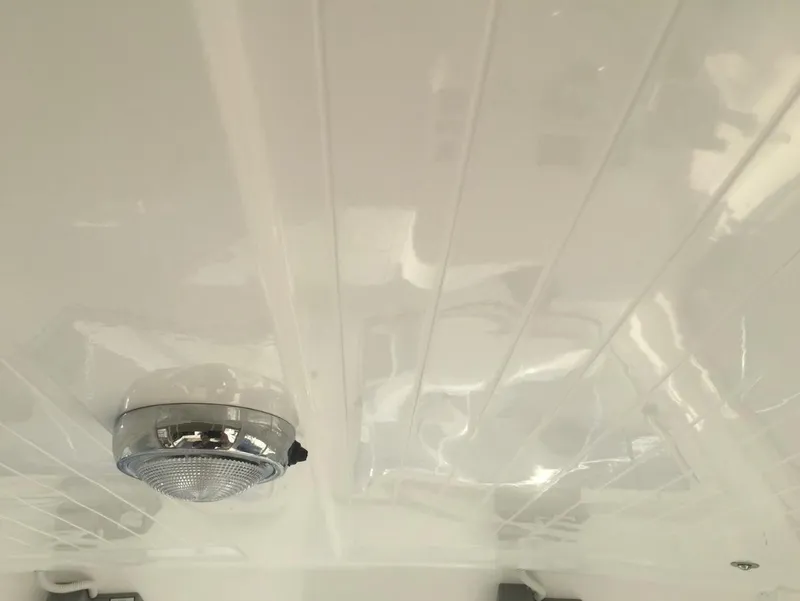 Slide: The Image of Ceiling of 2024 NorthCoast 235 HT boat with a mounted light fixture. - 18