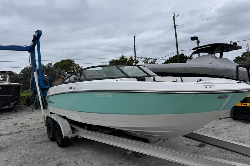 Slide: The Image of 2020 Monterey M-225 boat on trailer, mint green and white, parked outdoors. - 1