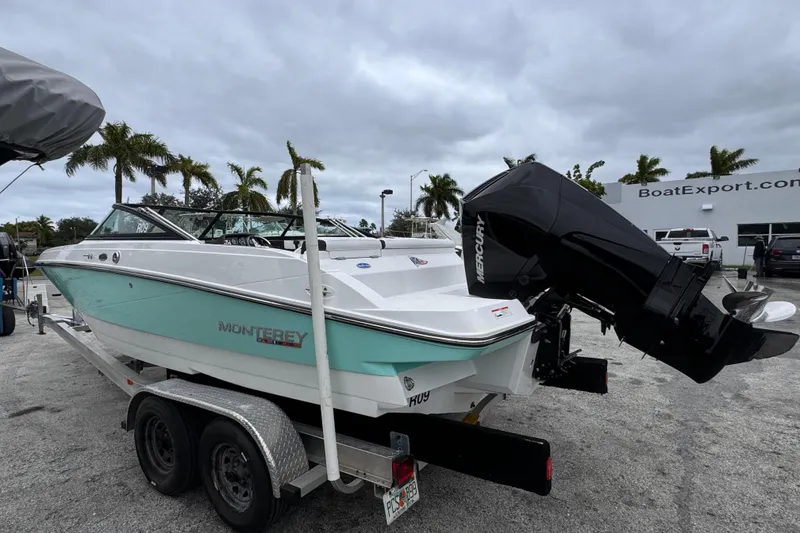 Slide: The Image of 2020 Monterey M-225 boat on trailer, with Mercury outboard motor, parked near palm trees. - 3