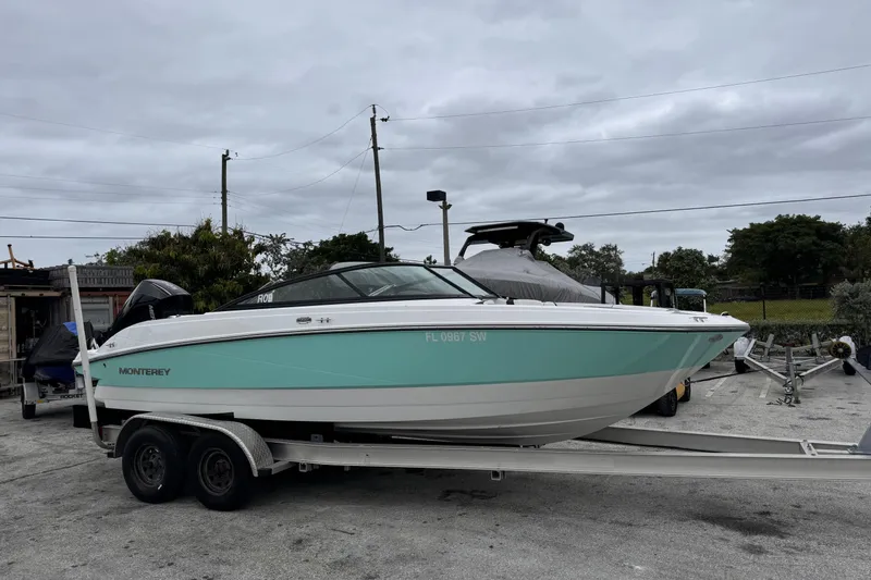 Slide: The Image of 2020 Monterey M-225 boat on trailer, parked outdoors under cloudy sky. - 8