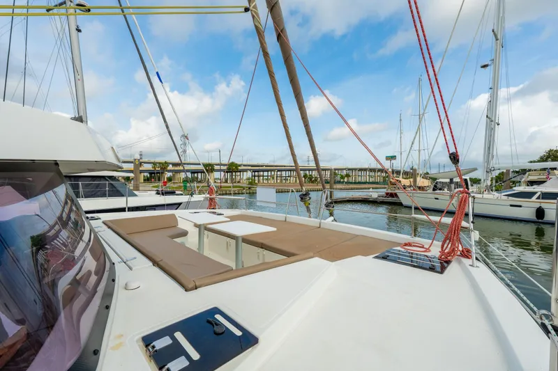 Slide: The Image of Spacious deck seating on a 2019 Bali 4.1 catamaran in a marina setting. - 58