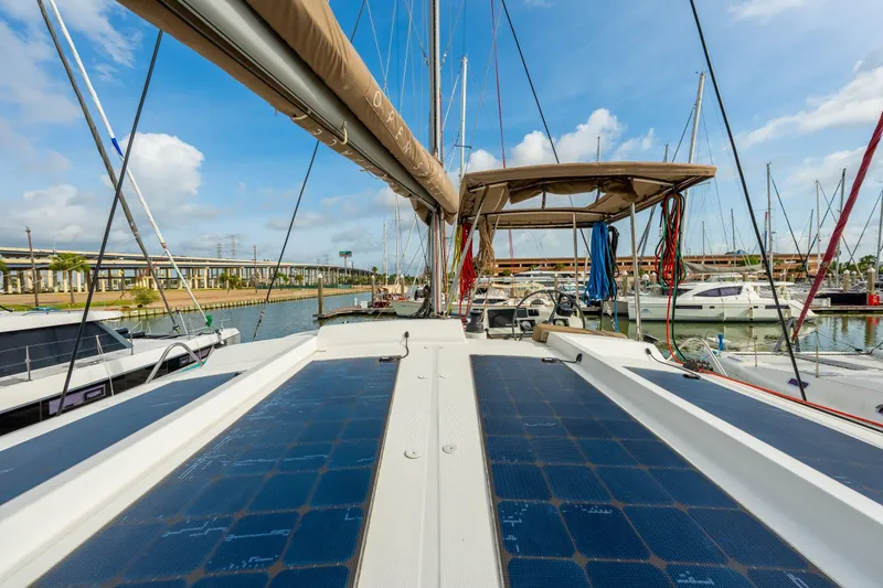 Slide: The Image of Sailboat Bali 4.1 from 2019 cruising on calm green waters under cloudy skies. - 72