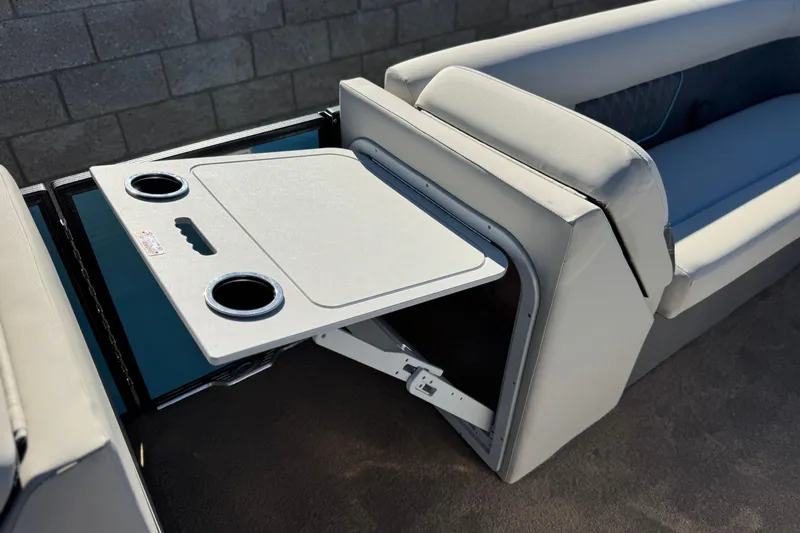 Slide: The Image of 2021 Crest Classic Platinum 240 SLC boat interior with foldable table and cup holders. - 13