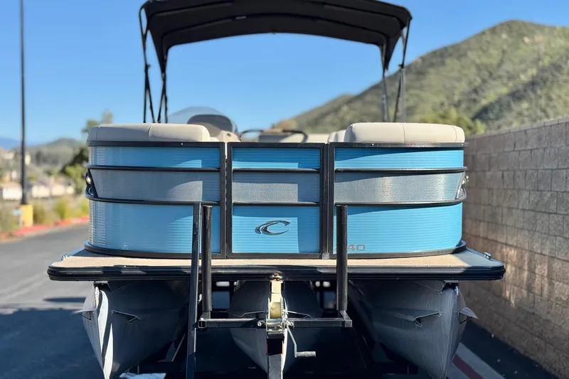 Slide: The Image of 2021 Crest Classic Platinum 240 SLC pontoon boat, blue exterior, parked outdoors. - 2