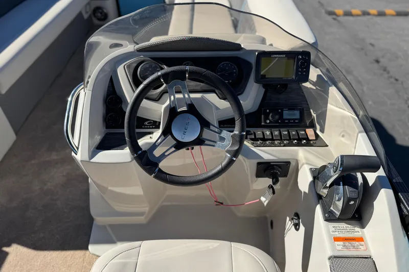 Slide: The Image of 2021 Crest Classic Platinum 240 SLC boat dashboard with steering wheel and controls. - 26