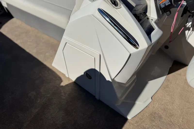 Slide: The Image of 2021 Crest Classic Platinum 240 SLC boat console with storage compartment and control panel. - 28