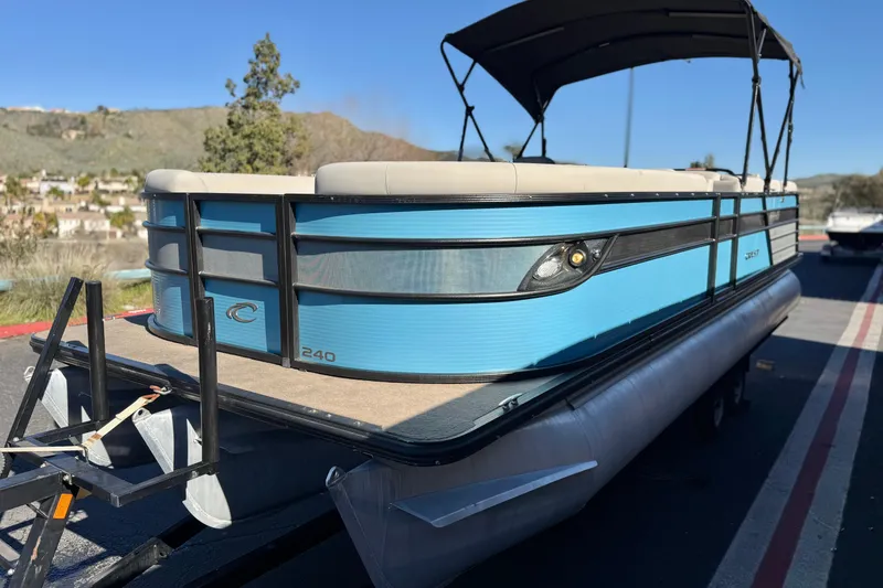 Slide: The Image of 2021 Crest Classic Platinum 240 SLC pontoon boat with blue exterior on trailer. - 3