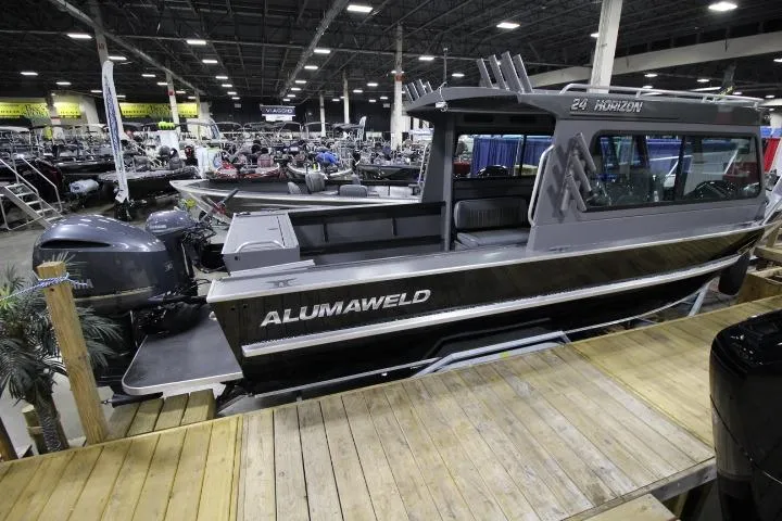 Slide: The Image of 2026 Alumaweld Horizon 24 boat displayed at an indoor boat show. - 0
