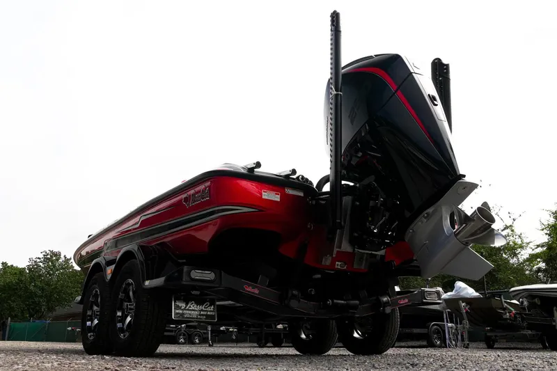 Slide: The Image of 2026 Bass Cat Cougar FTD Special Package boat, rear view with powerful engine, parked outdoors. - 11