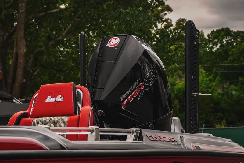 Slide: The Image of 2026 Bass Cat Cougar FTD boat with Mercury Pro XS engine, red seats, and lush green background. - 52