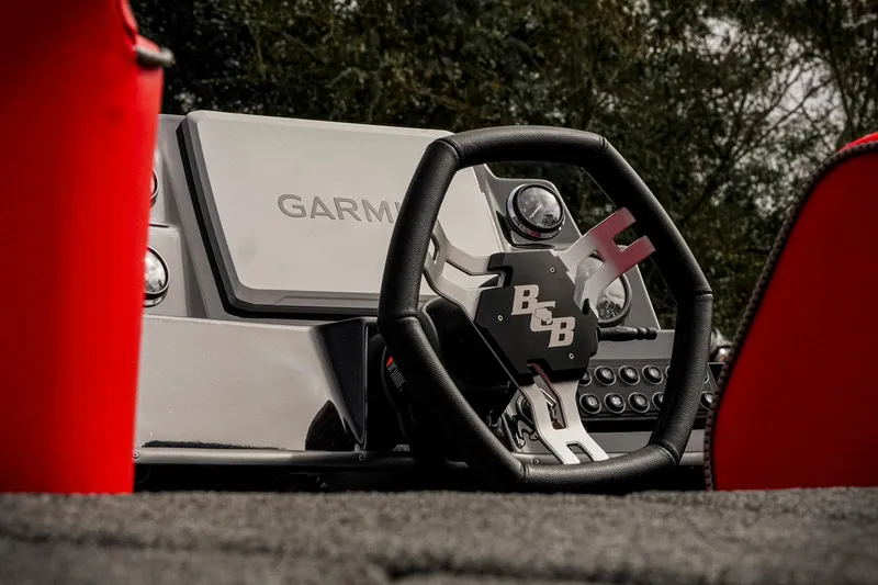 Slide: The Image of 2026 Bass Cat Cougar FTD boat dashboard with Garmin display and steering wheel. - 8