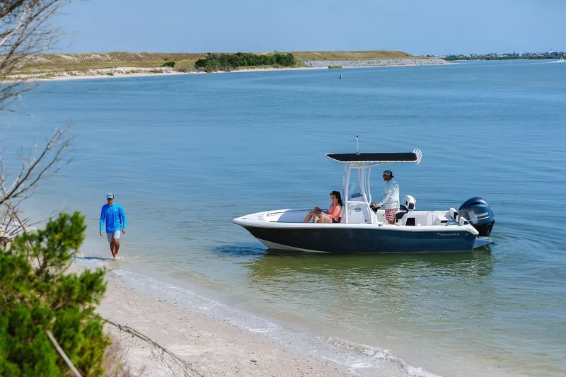 Slide: The Image of 2026 Tidewater 198 CC Adventure boat near sandy shore with people enjoying a sunny day. - 4