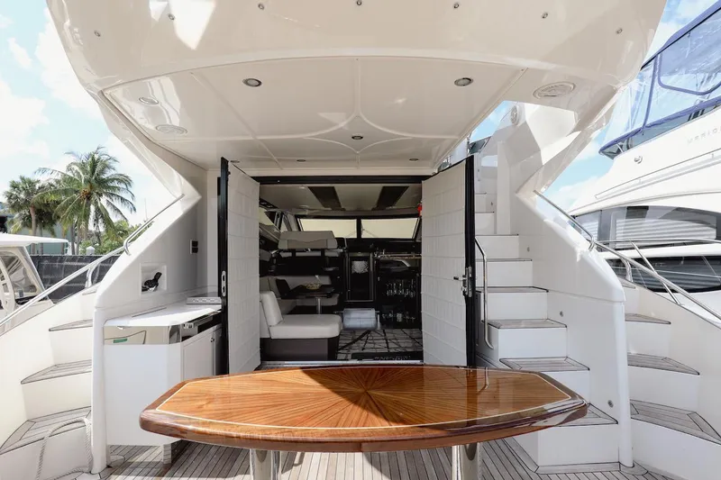 Slide: The Image of 2017 Marquis 500 Sport Yacht interior with wooden table and white seating. - 11