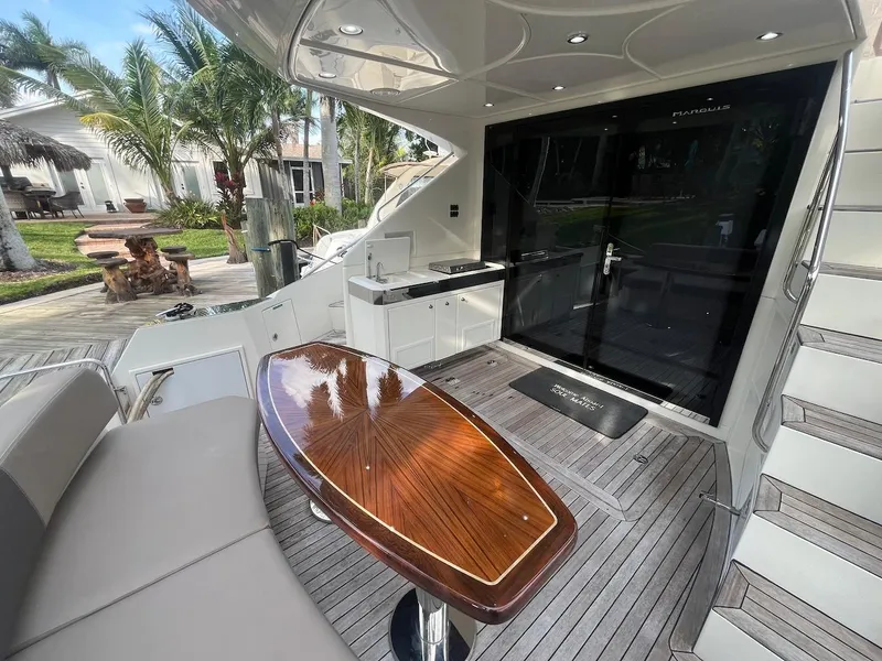 Slide: The Image of 2017 Marquis 500 Sport Yacht deck with seating, table, and outdoor kitchen. - 22
