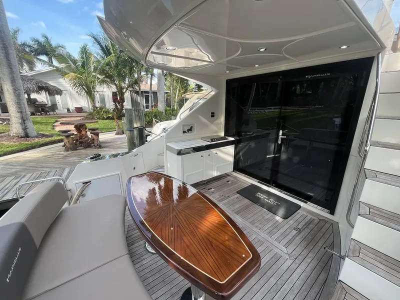 Slide: The Image of 2017 Marquis 500 Sport Yacht deck with seating, table, and outdoor kitchen. - 23