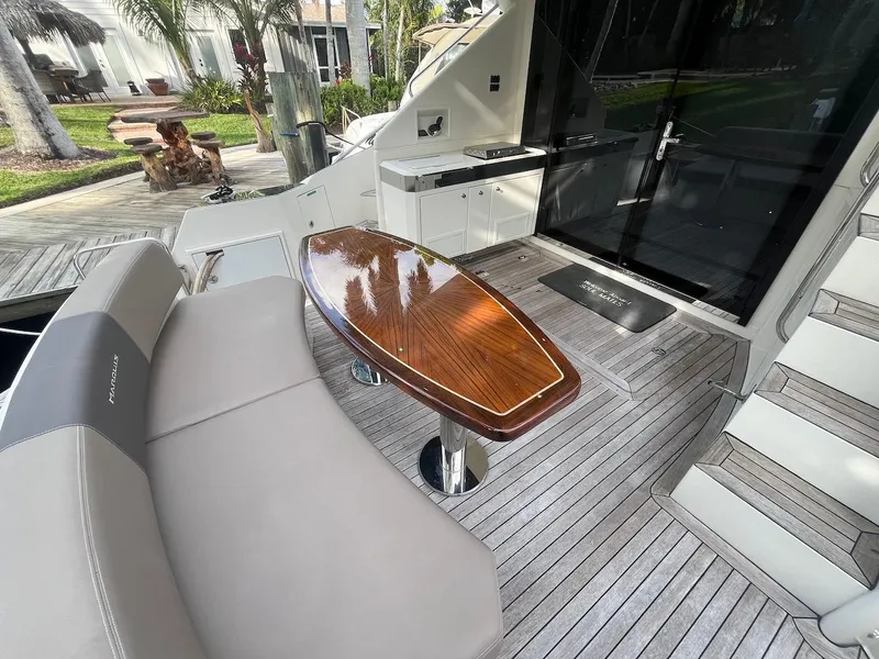 Slide: The Image of 2017 Marquis 500 Sport Yacht deck with seating and wooden table. - 24