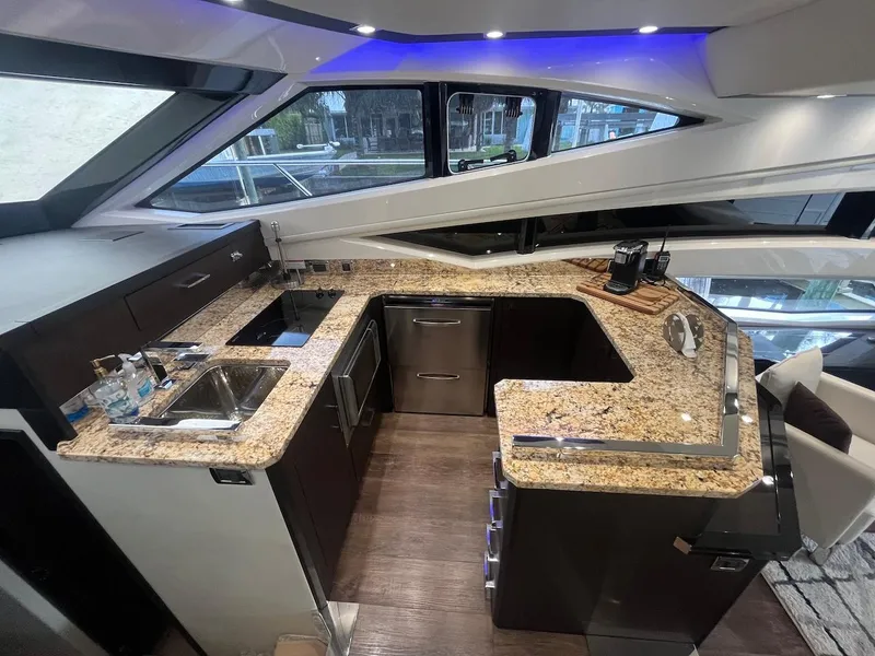 Slide: The Image of 2017 Marquis 500 Sport Yacht kitchen with granite countertops and modern appliances. - 28