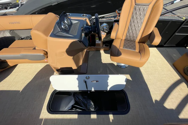 Slide: The Image of 2026 Harris Cruiser 210 boat interior with tan seating and storage compartment. - 10