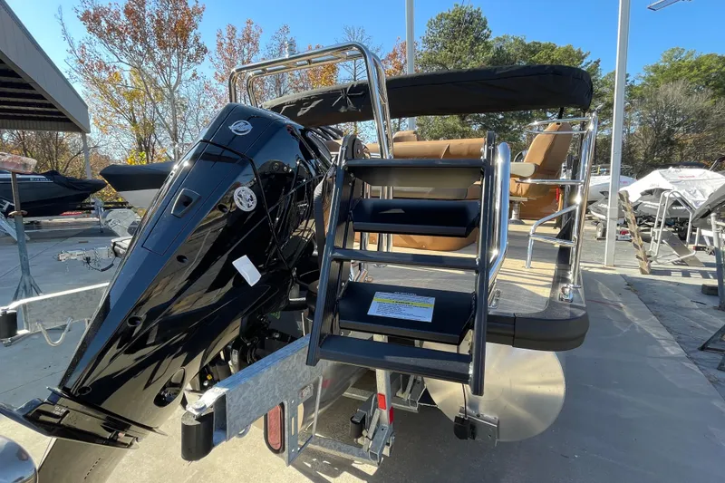 Slide: The Image of 2026 Harris Cruiser 210 boat with outboard motor and boarding ladder, docked outdoors. - 15