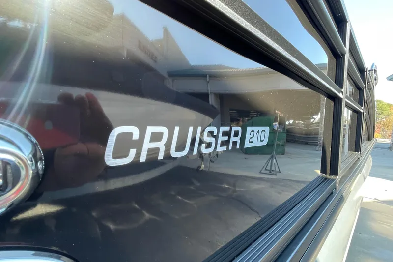 Slide: The Image of 2026 Harris Cruiser 210 boat exterior with logo in sunlight. - 18