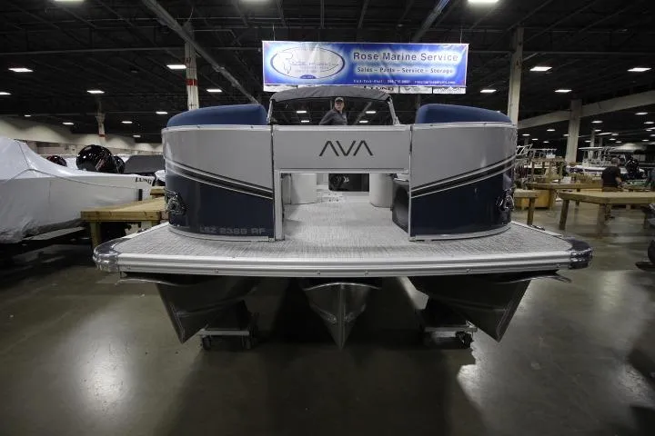 Slide: The Image of 2026 Avalon LSZ Rear Fish pontoon boat displayed indoors at a marine service center. - 2