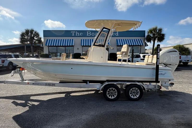 The Image of 2026 Scout 231 XSB boat on trailer outside dealership, sunny day. - 1