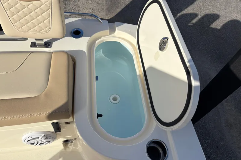 Slide: The Image of 2026 Scout 231 XSB boat with open storage compartment and cushioned seating. - 10