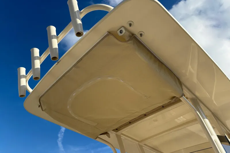Slide: The Image of 2026 Scout 231 XSB boat top view with rod holders against blue sky. - 14