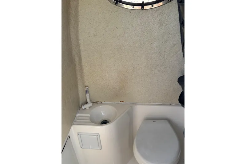 Slide: The Image of 2013 Wellcraft 30 Scarab Sport boat interior with seating, docked under clear blue sky. - 16