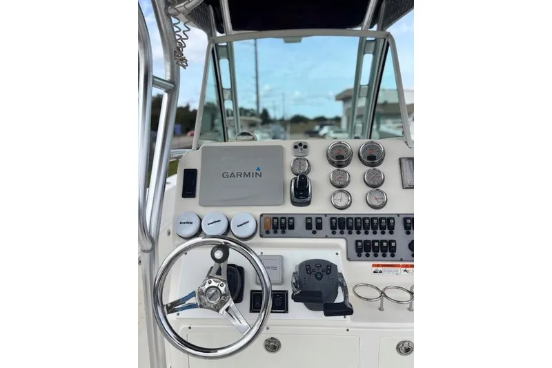 Slide: The Image of 2013 Wellcraft 30 Scarab Sport boat with dual outboard engines, parked on a sunny day. - 5