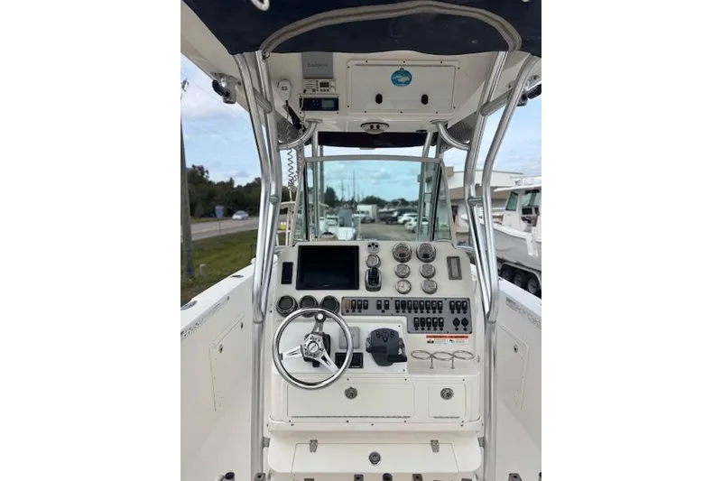 Slide: The Image of 2013 Wellcraft 30 Scarab Sport boat cockpit with steering wheel and control panel. - 8