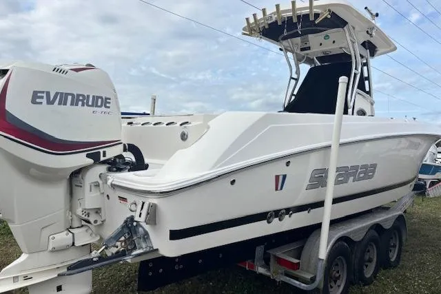 Slide: The Image of 2013 Wellcraft 30 Scarab Sport boat with dual Evinrude engines on a trailer. - 4