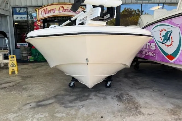 Slide: The Image of 2023 Carolina Skiff 162 JLS boat displayed in a showroom with festive decorations. - 11